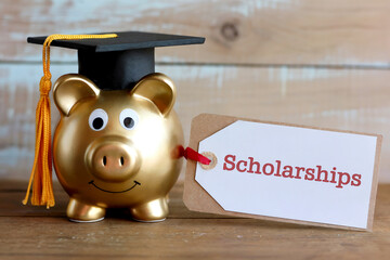Golden piggy bank with graduation cap and scholarships tag mortarboard