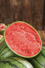 Fresh Cut Watermelon Half with Juicy Red Flesh on Wooden Background