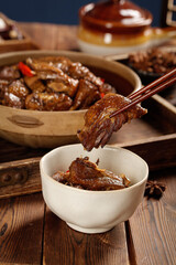 Traditional Asian Braised Duck Stew with Chopsticks in Ceramic Bowl on Rustic Wooden Table