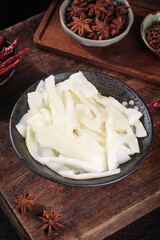 Fresh Bamboo Shoots Sliced in Bowl with Star Anise and Spices on Wooden Background for Asian Cooking