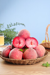 Freshly Picked Red Flesh Blood Peaches from Hubei in Wicker Basket on Wooden Table