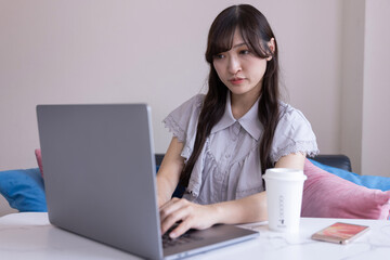 A Japanese woman working by laptop in the living room
