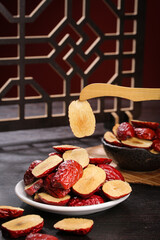 Ruoqiang Red Dates from Xinjiang China - Traditional Dried Jujube Fruit on Wooden Spoon with Asian Lattice Background
