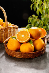 Freshly harvested oranges in wicker baskets with green leaves - healthy citrus fruit display
