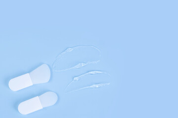 Beauty spatulas and clear gel texture on blue surface, copy space, skincare concept.