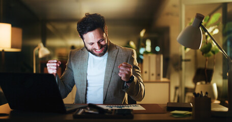 Excited, businessman and night with fist pump on laptop for winning, investment or promotion at office. Happy, man or employee working late with smile, graphs and good news or celebration for bonus