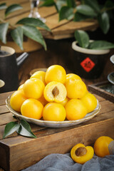 Fresh Yellow Apricots on White Plate - Xinjiang Stone Fruit Display on Rustic Wooden Table