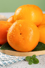 Fresh Persimmons with Water Droplets in Wooden Bowl - Sweet Crisp Autumn Fruit