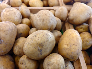 Fresh Golden Potatoes in Wooden Crate at Marketplace Display