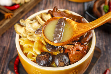 Golden Mushroom Soup with Mixed Fungi in Traditional Wooden Bowl