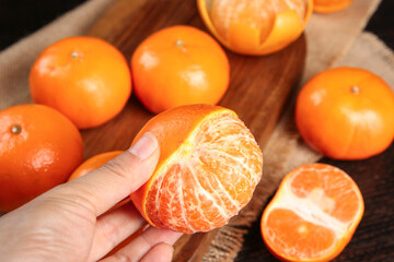 Fresh Seedless Mandarin Orange Peeled by Hand on Wooden Cutting Board - Bountiful Citrus Harvest from Guangxi