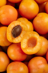 Fresh Xinjiang Apricots Cut in Half Showing Pit and Orange Flesh on Wooden Background