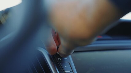 Pressing button on car dashboard with hand near steering wheel control driver interior closeup showing finger activating climate and audio control in modern vehicle cabin press detail user interaction