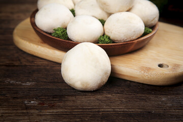Fresh White Button Mushrooms in Wooden Bowl on Rustic Wood Table