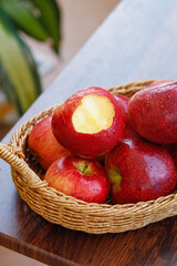 Fresh Red Apples with Morning Dew in Wicker Basket - One Bitten Apple Showing Interior