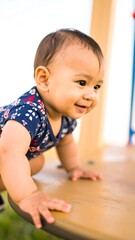 Infant exploring playground, smiling