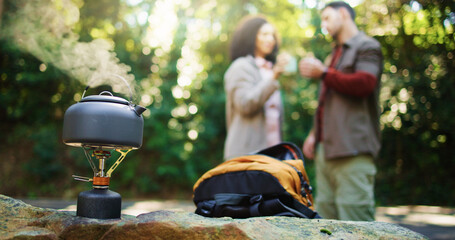 Travel kettle, couple and nature with backpack for hiking break, rest or camp out in forest. Equipment, gear or coffee with man and woman for trekking stop, drink or outdoor beverage in wilderness