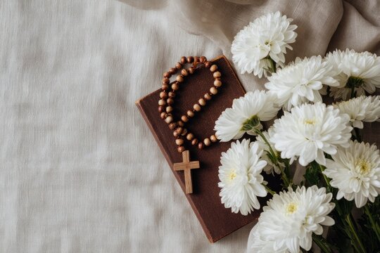 serene arrangement featuring flowers, rosary beads, and book cre