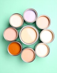 Paint cans in a circle, various pastel and earthy tones on mint background