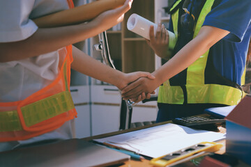 Closeup of team of industrial engineers meeting analyze machinery blueprints consult project on table in manufacturing factory. Working in manufacturing plant or production plant.