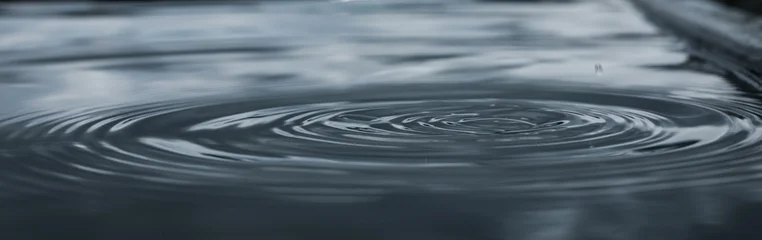 Stickers Ziekenhuis Raindrops fall gently on water creating soothing ripples  © Atlas