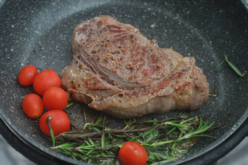
Pan-fried steak with red tomatoes and rosemary