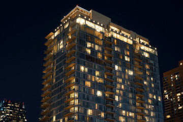 Fototapeta premium A luxury condominium tower glowing at night Windows sparkle across the skyline The mood feels glamorous and vibrant