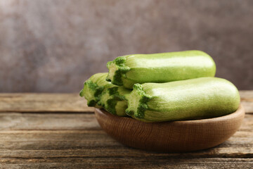 Fresh ripe zucchinis on wooden table, closeup. Space for text