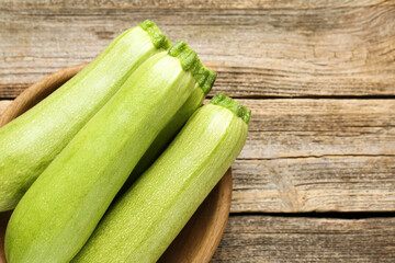 Fresh ripe zucchinis on wooden table, above view. Space for text
