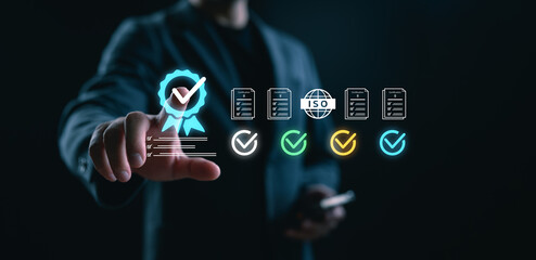 Businessman selecting quality assurance certification icon on virtual screen. Concept of ISO...