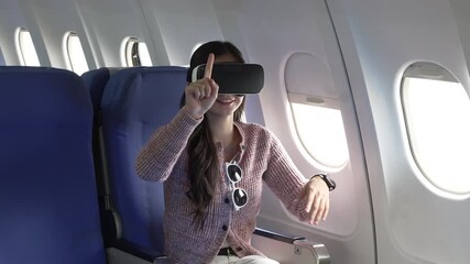 Asian businesswoman wearing VR headset while sitting on an airplane.Immersed in virtual reality entertainment,exploring technology,enjoying a futuristic immersive travel experience during her flight - Powered by Adobe