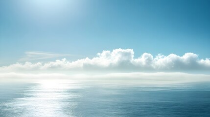 Obraz premium Calm ocean surface under a bright sky with fluffy clouds