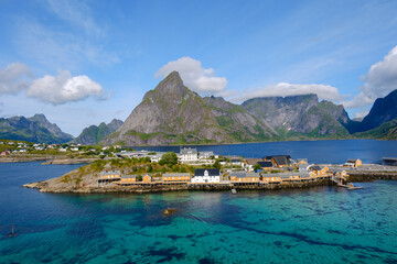 Sakrisoy village offers stunning landscapes with vibrant buildings nestled against towering mountains and crystal-clear waters. The serene atmosphere captivates visitors all year round.