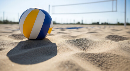 A volleyball rests on a sandy beach, with a volleyball net visible in the background.