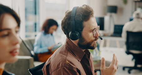 Headset, man and call center consultant in office with crm, communication or coworking. Talking,...