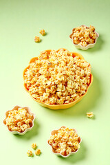 Buttery Popcorn in Colorful Bowls on Green Background - Snack Food Photography