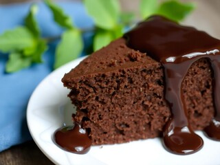 Delicious slice of rich chocolate cake drizzled with glossy chocolate sauce