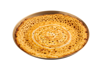 Golden, crispy flatbread, delicately patterned, sits in a round pan against a black background.