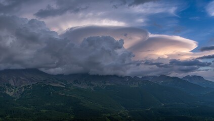 Featuring lenticular cloud hovering above peaks in valley, cumulonimbus clouds, conifer forest