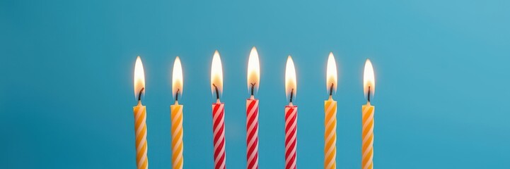 Five brightly lit birthday candles glow against a smooth blue background, birthday, macro