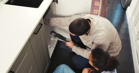 Kid, help and father with tools at house for plumbing, repair sink and support for maintenance....