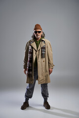 Stylish elder man showcasing modern fashion with confidence and flair in a minimalist studio setting