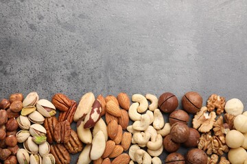 Mix of different nuts on grey table, flat lay. Space for text