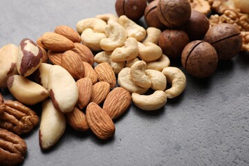 Mix of different nuts on grey table, closeup. Space for text