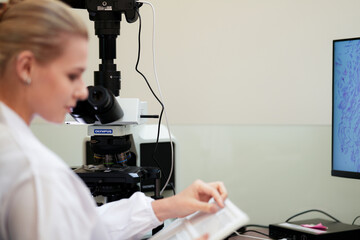 A pathologist performs a quality control check, comparing a physical glass slide with its whole slide image WSI on a digital pathology workstation for a final diagnosis.