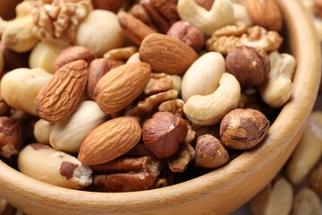 Mix of different nuts in bowl on table, closeup