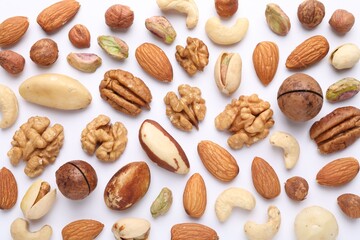 Mix of different nuts on white background, flat lay