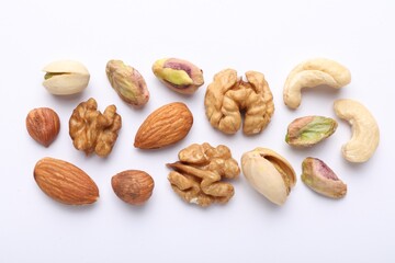 Mix of different nuts on white background, flat lay