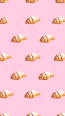 Obraz premium Croissants arranged in a repeating pattern on a pastel pink background