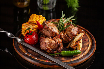 Grilled pork skewers with vegetables on wooden plate